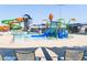 A view of the community pool, with lounge chairs, waterslides and a zero entry splash pad at 18346 W Sweet Acacia Dr, Goodyear, AZ 85338