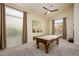 A lovely carpeted game room with pool table and nice natural light at 18346 W Sweet Acacia Dr, Goodyear, AZ 85338