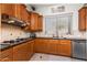 Well-lit kitchen featuring wooden cabinets, granite countertops, and stainless steel appliances at 18346 W Sweet Acacia Dr, Goodyear, AZ 85338