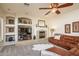 Cozy living room featuring a fireplace, built-in shelving, and comfortable seating at 18346 W Sweet Acacia Dr, Goodyear, AZ 85338
