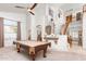 Spacious living room with billiard table, white walls, and elegant staircase to the upper level at 18346 W Sweet Acacia Dr, Goodyear, AZ 85338