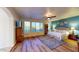Spacious bedroom with a blue accent wall features laminate floors, a ceiling fan, and backyard views at 18346 W Sweet Acacia Dr, Goodyear, AZ 85338