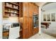Home office with built-in desk, wooden cabinetry, and integrated microwave and oven at 18346 W Sweet Acacia Dr, Goodyear, AZ 85338