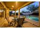 Covered outdoor patio with dining table overlooks the beautiful private pool at 18346 W Sweet Acacia Dr, Goodyear, AZ 85338