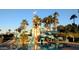 Fun pool area featuring a lighthouse and slides, surrounded by palm trees offering a resort-like experience at 18346 W Sweet Acacia Dr, Goodyear, AZ 85338
