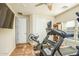 Home workout room featuring wood floors, a ceiling fan, and plenty of workout equipment at 18346 W Sweet Acacia Dr, Goodyear, AZ 85338