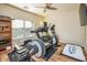 Home workout room featuring wood floors, a ceiling fan, and plenty of workout equipment at 18346 W Sweet Acacia Dr, Goodyear, AZ 85338