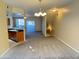 Open-concept living area with carpet flooring, chandelier lighting and adjacent kitchen at 1920 E Bell Rd # 1006, Phoenix, AZ 85022