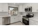 Modern kitchen with white cabinets, stainless steel appliances, and quartz countertops at 20230 N 126Th Ave, Sun City West, AZ 85375