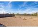 An open backyard has fresh landscaping, concrete fence, and gravel at 25364 W Sunland Ave, Buckeye, AZ 85326