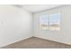 Bright, empty bedroom with carpeted flooring and a large window at 25364 W Sunland Ave, Buckeye, AZ 85326