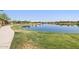 Picturesque lake with walking path and seating areas providing a serene setting for residents at 25424 S 224Th Pl, Queen Creek, AZ 85142
