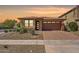 Charming single-story home with desert landscaping, brick driveway, and a welcoming front entrance at 25424 S 224Th Pl, Queen Creek, AZ 85142