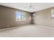Main bedroom with neutral carpeting and walls, bright windows and ceiling fan at 25424 S 224Th Pl, Queen Creek, AZ 85142