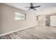 Spacious bedroom with new flooring, modern ceiling fan, natural light, and a sliding barn door closet at 3315 W Shaw Butte Dr, Phoenix, AZ 85029