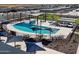 Aerial view showcases a resort-style pool area with lounge chairs, splash pad, cabanas, and mountain views at 3513 E Audrey Dr, San Tan Valley, AZ 85143
