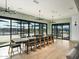 Bright dining area with a long wooden table, modern light fixtures, and sliding glass doors to outdoor amenities at 3513 E Audrey Dr, San Tan Valley, AZ 85143