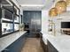 Elegant kitchen with navy cabinets, stainless steel appliances, marble counters, and woven pendant lighting at 3513 E Audrey Dr, San Tan Valley, AZ 85143