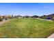 Expansive community green space with walking path and views of the neighborhood homes under a clear blue sky at 35493 N Seedling St, San Tan Valley, AZ 85144