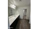 Bathroom with sleek wood flooring, glass shower, and double sink vanity with walk in closet at 36992 W Capri Ave, Maricopa, AZ 85138
