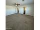 Spacious bedroom with plush carpeting, ceiling fan, and access to adjacent bathroom at 36992 W Capri Ave, Maricopa, AZ 85138