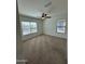 Bright bedroom featuring carpet, ceiling fan, and natural light from two windows at 36992 W Capri Ave, Maricopa, AZ 85138