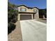Two-story home with low maintenance landscaping and large driveway surrounded by a small tree at 36992 W Capri Ave, Maricopa, AZ 85138