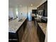 Bright kitchen with stainless steel appliances, granite counters, and dark cabinets at 36992 W Capri Ave, Maricopa, AZ 85138