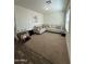 Spacious living room features neutral paint, large sofa, and plush carpeting at 36992 W Capri Ave, Maricopa, AZ 85138