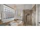 Luxurious bathroom showcasing a soaking tub, glass shower, and a decorative glass block window at 3953 E Lafayette Ave, Gilbert, AZ 85298