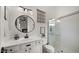 Modern bathroom featuring a glass shower, round mirror, and sleek white vanity with black hardware at 3953 E Lafayette Ave, Gilbert, AZ 85298