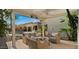 Inviting covered patio with comfortable seating, ceiling fan, heater, and TV, overlooking a lush backyard with a sparkling pool at 3953 E Lafayette Ave, Gilbert, AZ 85298