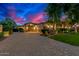 Elegant home featuring a spacious driveway and exterior lighting, set against a vibrant twilight sky at 4431 E Gemini Pl, Chandler, AZ 85249
