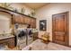 Well-equipped laundry room boasts stainless steel washer/dryer, wooden cabinets, and stylish travertine floors at 4431 E Gemini Pl, Chandler, AZ 85249