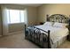 Cozy bedroom featuring carpet flooring, window with white drapes, and iron bed frame at 4750 W Saddlehorn Rd, Phoenix, AZ 85083