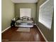 Cozy bedroom with hardwood floors, natural light, and a comfortable daybed for guests at 4750 W Saddlehorn Rd, Phoenix, AZ 85083