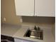 Laundry room sink with white cabinets and grey countertops at 4750 W Saddlehorn Rd, Phoenix, AZ 85083