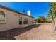 A spacious backyard with gravel landscaping, white exterior and string lights overhead at 5622 E Gelding Dr, Scottsdale, AZ 85254