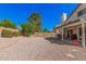 The large backyard includes a covered patio, gravel landscaping, mature trees and a privacy fence at 5622 E Gelding Dr, Scottsdale, AZ 85254