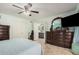 Large bedroom with ceiling fan and ensuite bathroom featuring dark wood furniture at 5622 E Gelding Dr, Scottsdale, AZ 85254