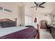Bedroom featuring a ceiling fan, ample closet space, and a vintage dresser with an adjacent workstation at 5622 E Gelding Dr, Scottsdale, AZ 85254