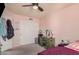 Cozy bedroom with ceiling fan and closet; features pink walls and carpet with neutral trim at 5622 E Gelding Dr, Scottsdale, AZ 85254
