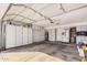 Clean garage featuring ample storage, white cabinets and a stainless steel refrigerator at 5622 E Gelding Dr, Scottsdale, AZ 85254