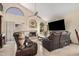 Inviting living room featuring a fireplace, ceiling fan, and leather furniture at 5622 E Gelding Dr, Scottsdale, AZ 85254