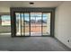 Bright unfinished living room with large sliding glass doors providing views of the surrounding neighborhood at 5631 W Summerside Rd, Laveen, AZ 85339