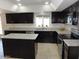 Well-equipped kitchen featuring dark cabinets, stainless appliances, granite counters, and tile flooring at 6242 E Hearn Rd, Scottsdale, AZ 85254