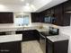 Modern kitchen with dark cabinetry, stainless steel appliances, and stylish granite countertops at 6242 E Hearn Rd, Scottsdale, AZ 85254