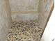 Custom shower with pebble floor, bench, and tan tile at 6242 E Hearn Rd, Scottsdale, AZ 85254