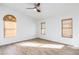 Bright bedroom featuring a ceiling fan, wood-look floors, and natural light streaming through the windows at 6439 W Adobe Dr, Glendale, AZ 85308