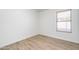 Neutral bedroom with wood floors, white walls, baseboard, and a window with adjustable blinds at 6439 W Adobe Dr, Glendale, AZ 85308